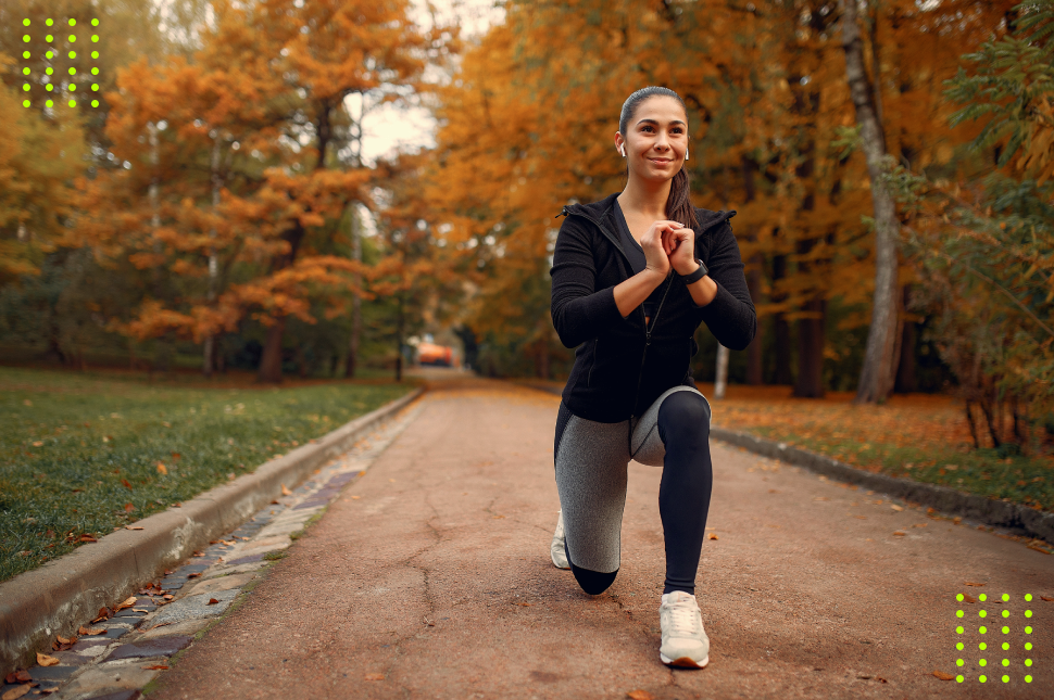 Mulher se exercitando em paisagem que remete ao outono, com árvores alaranjadas ao fundo